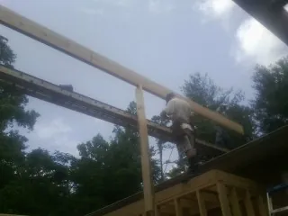 Carpenter setting a ridge beam over a new addition frame — Ice Dam Removal by Roofing Brothers in Lake Placid