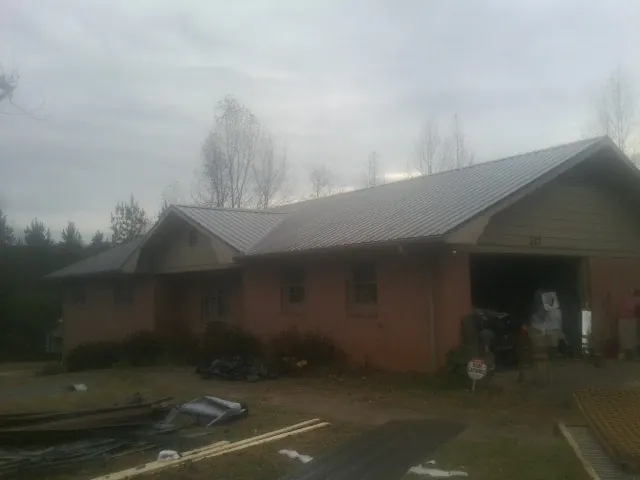 Gray metal roof on a stucco house with an attached garage in Lake Placid